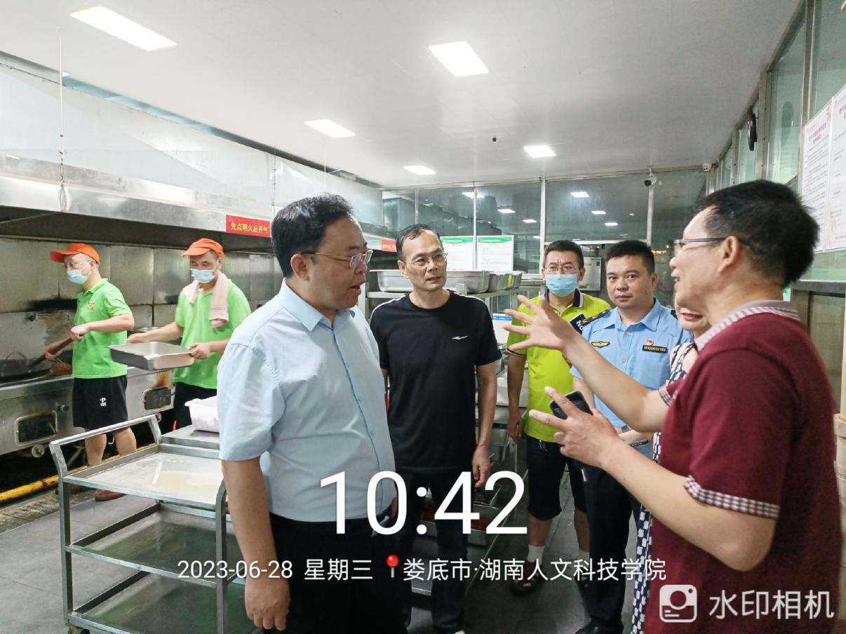 图2 蒋天海副市长在操作间检查食品安全、同时听取我校后勤基建处餐饮科负责人李小平的工作汇报