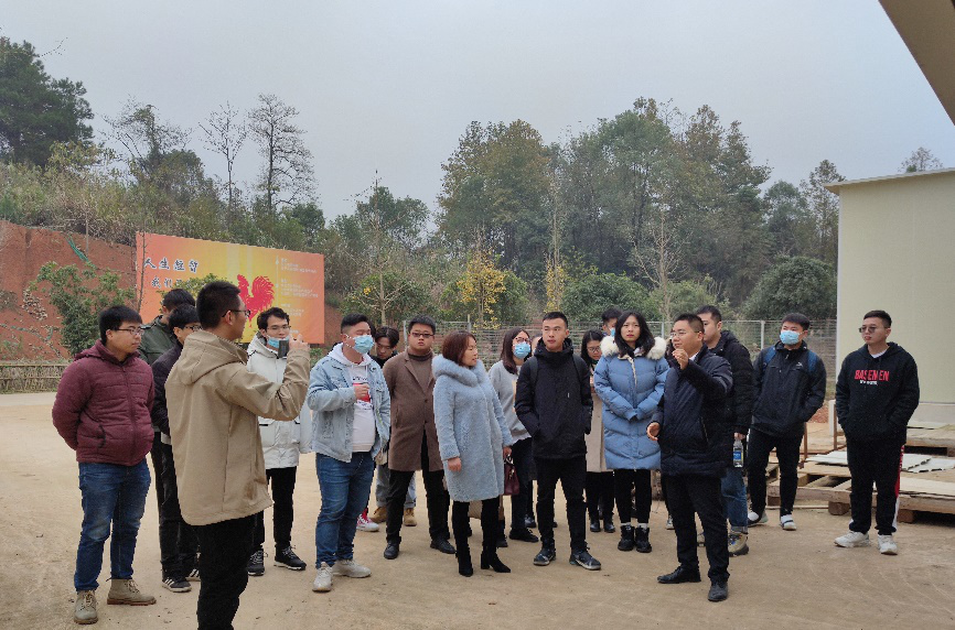 图一 龚光辉总经理在全自动化鸡舍前为研究生们做介绍